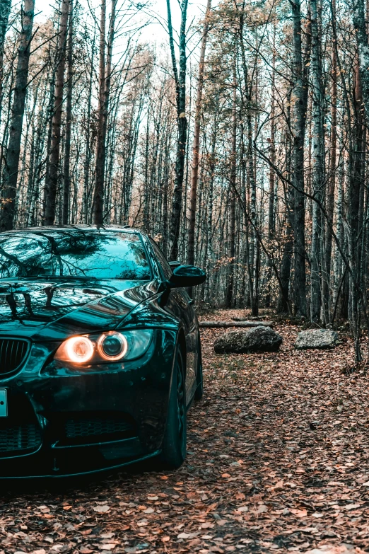 a black car parked in front of some trees