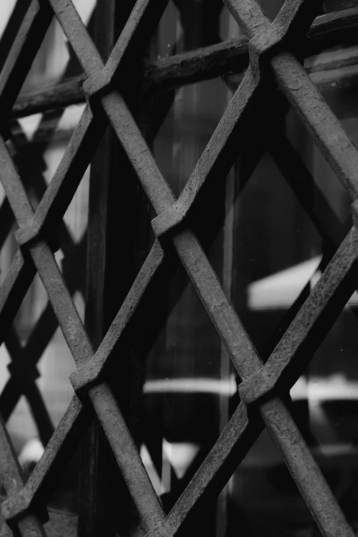 a black and white image of a latticed fence