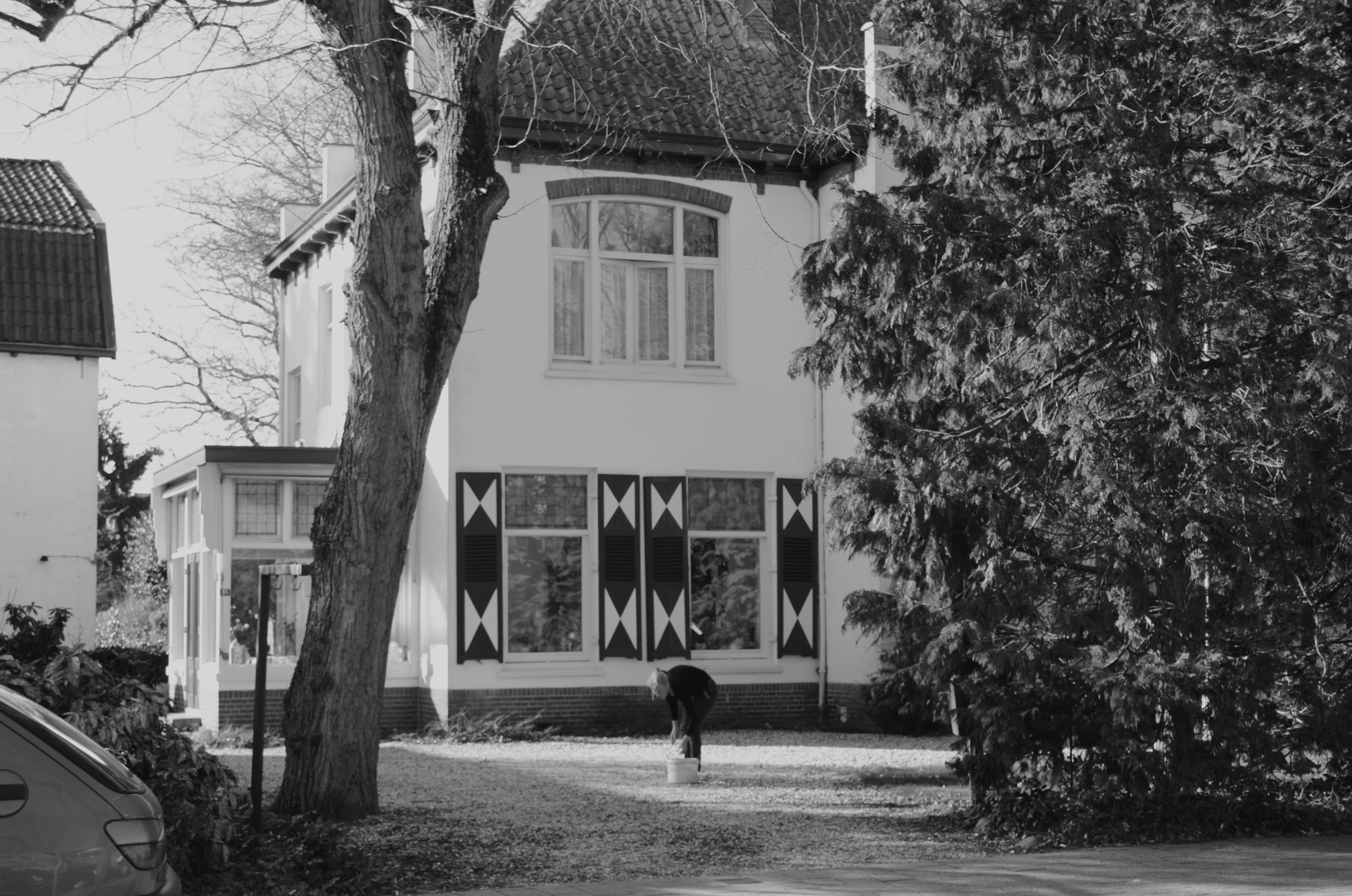 an old po of a person holding an umbrella in front of a building