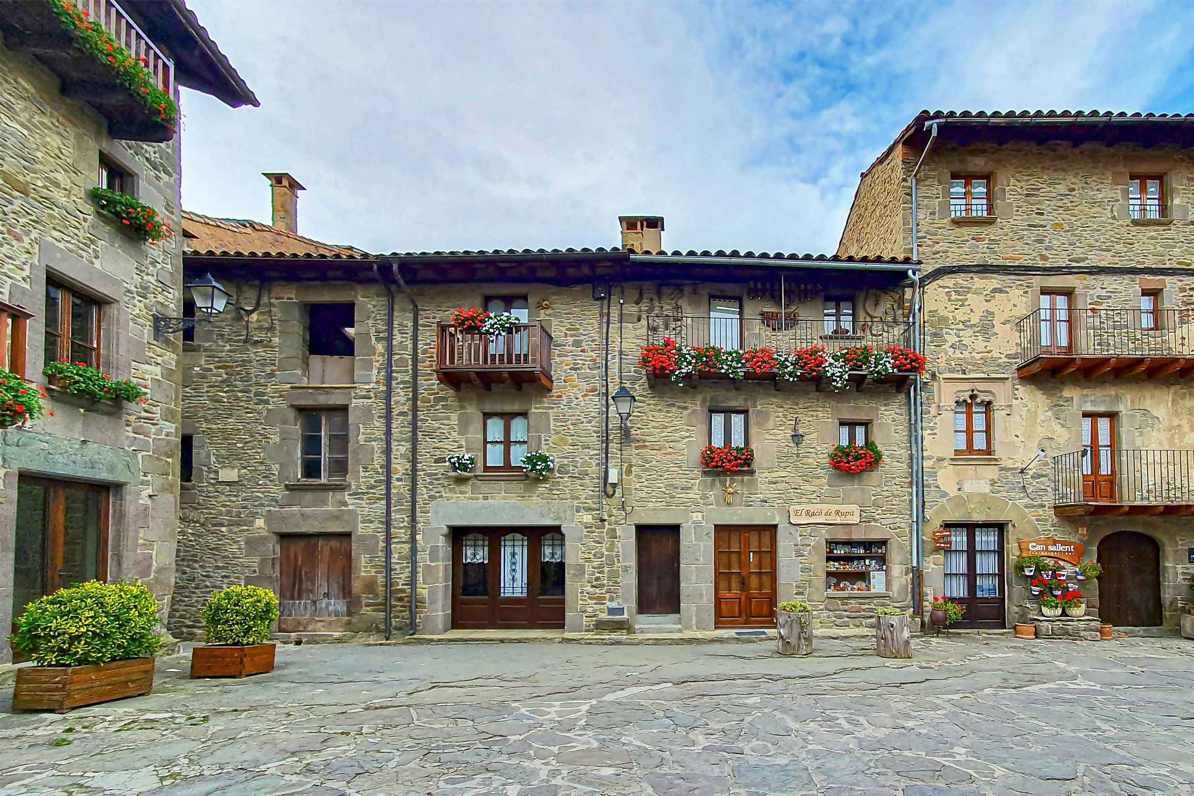 two large brick building with several flower pots