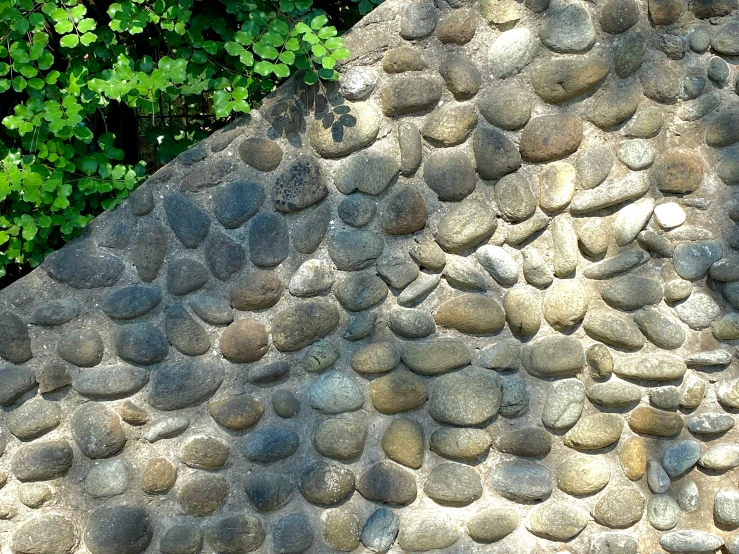 a large rock filled with smaller rocks next to trees