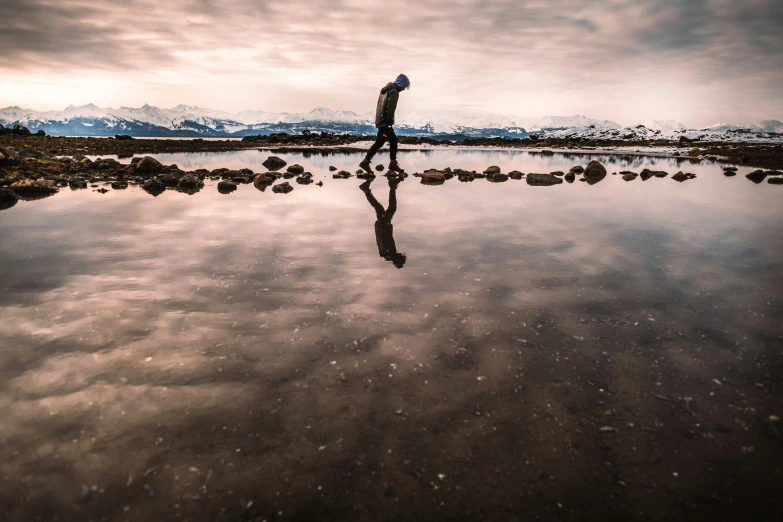 a man holding a surfboard is wading in shallow water