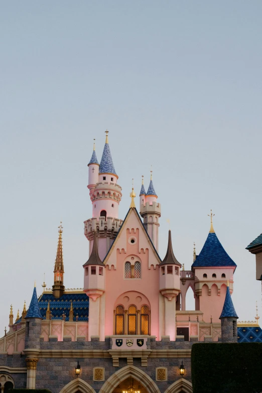 a pink castle with turrets and a clock tower