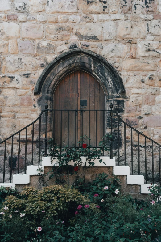 stairs leading up to an arched doorway with a fence over the door