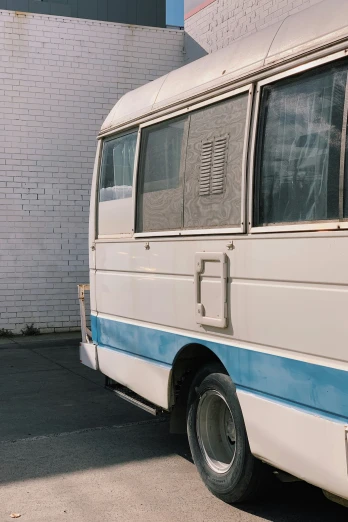 a white and blue bus parked in front of a brick building