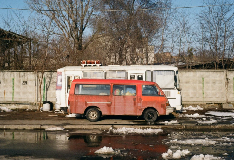 an orange van parked in front of a fence
