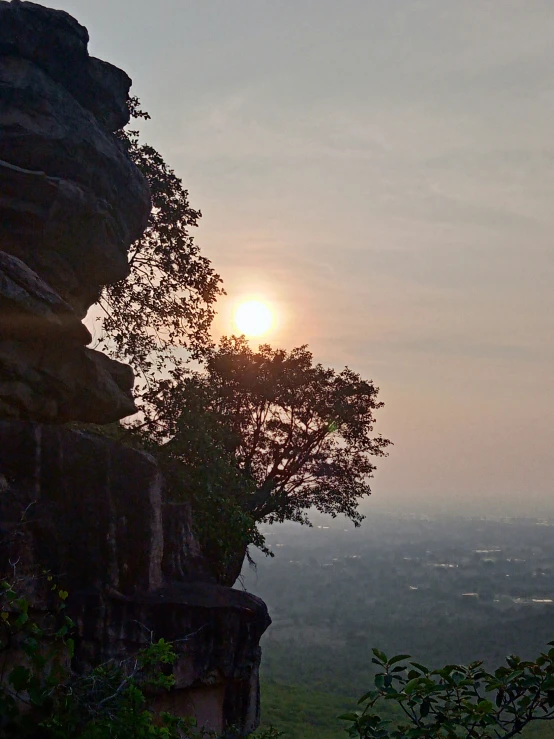 the sun is setting above the rock formations