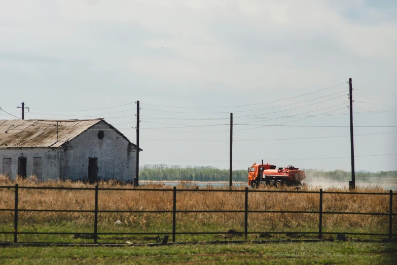 an old farm building with a tractor nearby