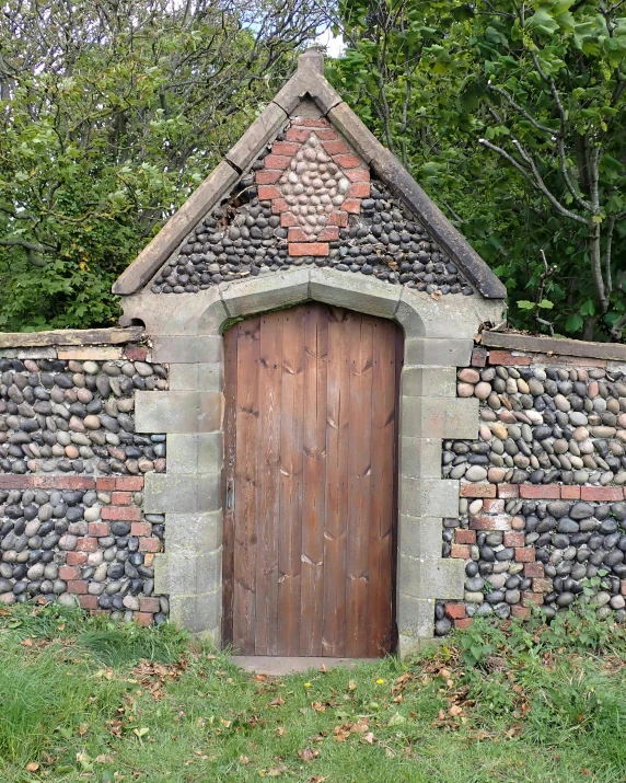 a wooden doorway that has an unusual brick wall and door