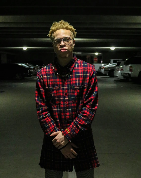 a man standing in a parking lot with his arms crossed