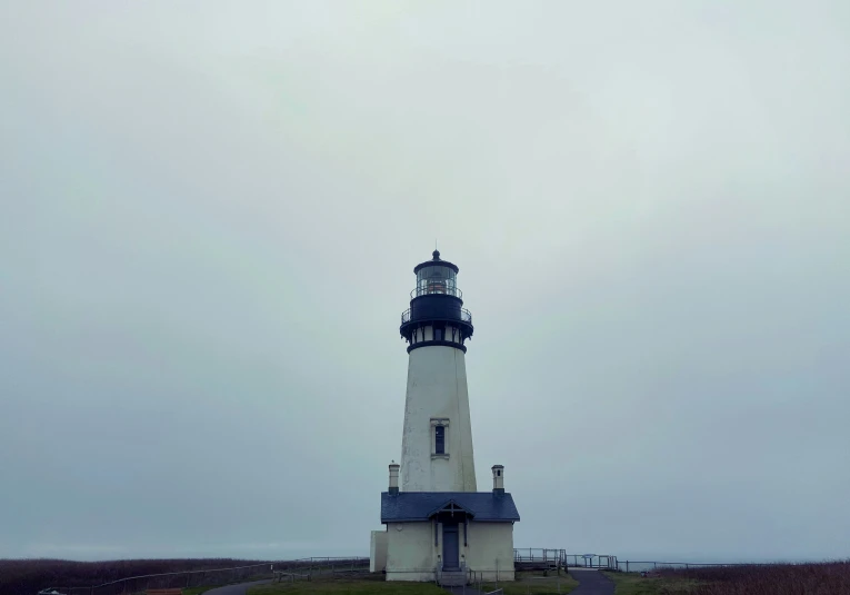 there is a light house that is sitting on the side of a hill