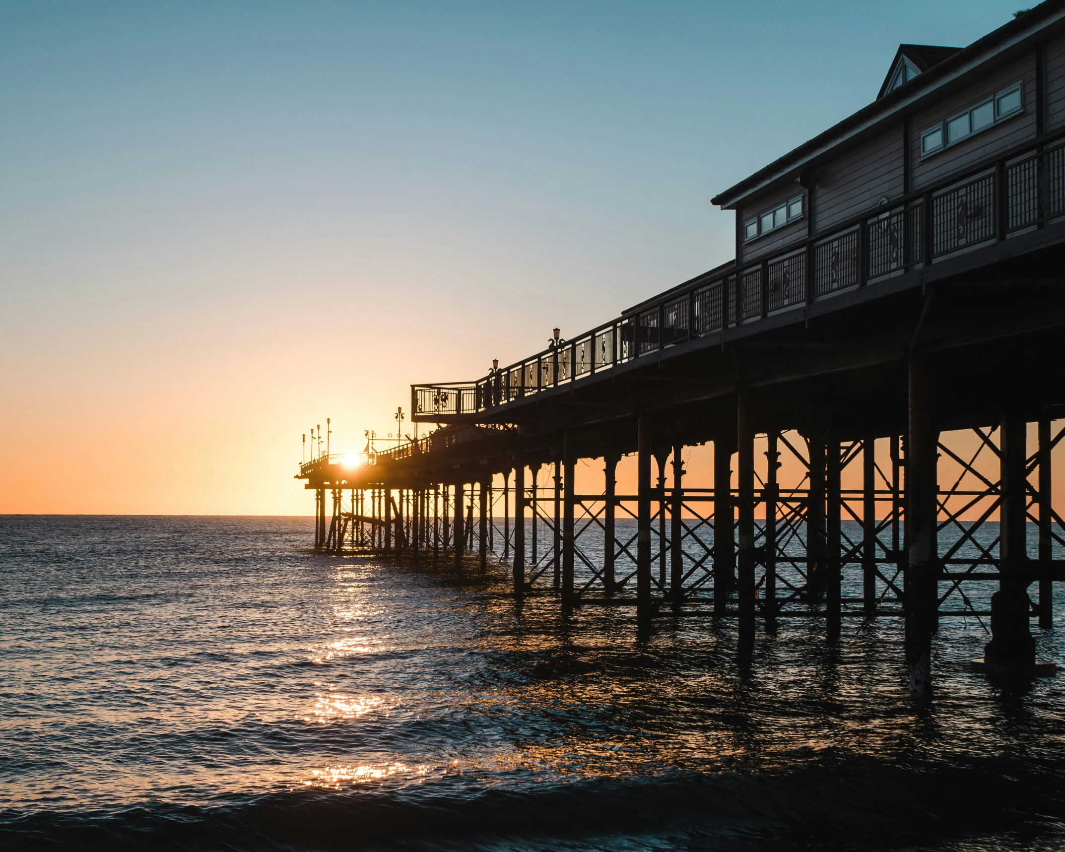 the pier at sunset with a person out for a ride