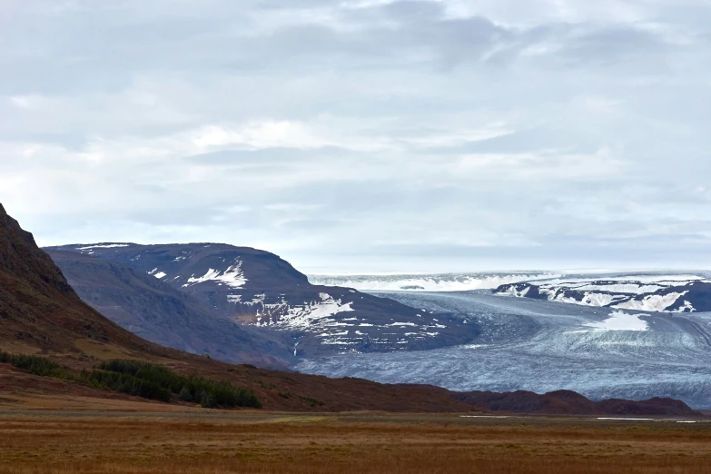 a couple of mountains with some animals in the grass