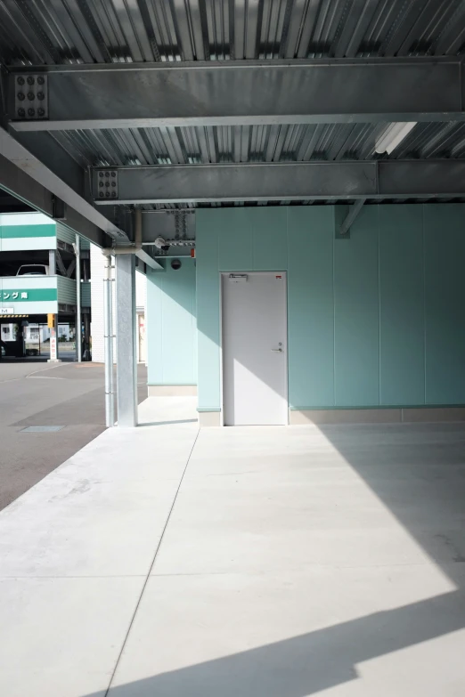 an empty building with green walls and a white door