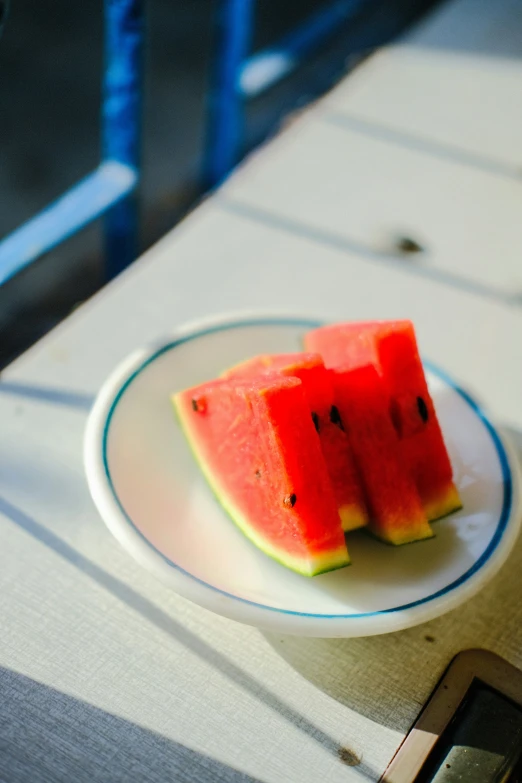a plate with slices of watermelon and a cell phone on it