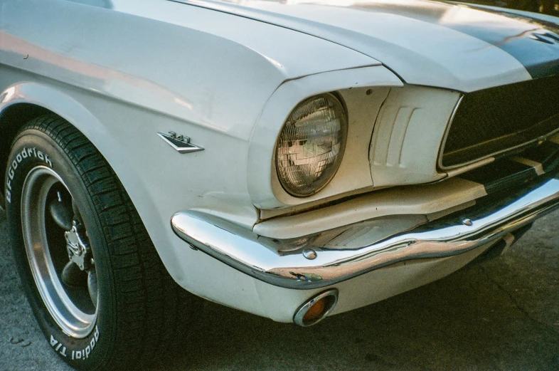 this is the front end of a white mustang in a parking lot