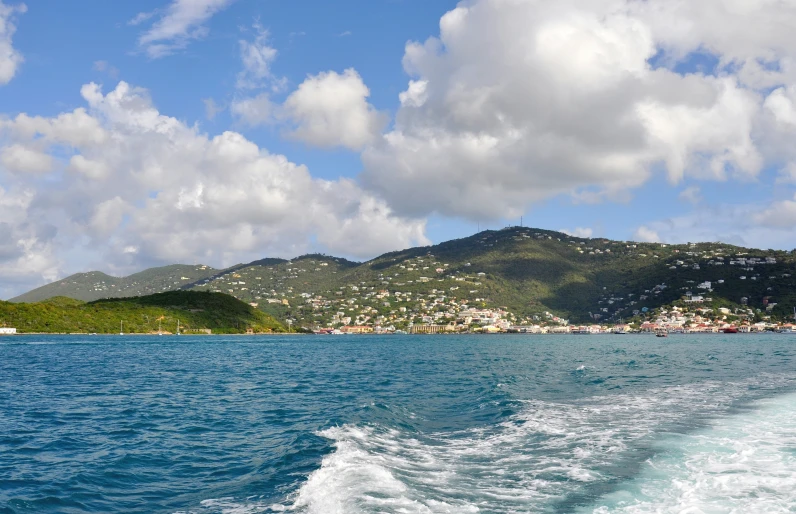 the wake of a boat traveling past the coastline