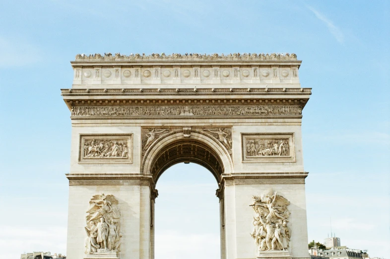 a large white stone archway to a small town