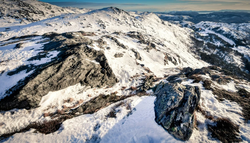 a large mountain covered in snow next to mountains