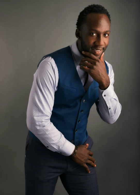 a man is standing in a blue suit and a tie