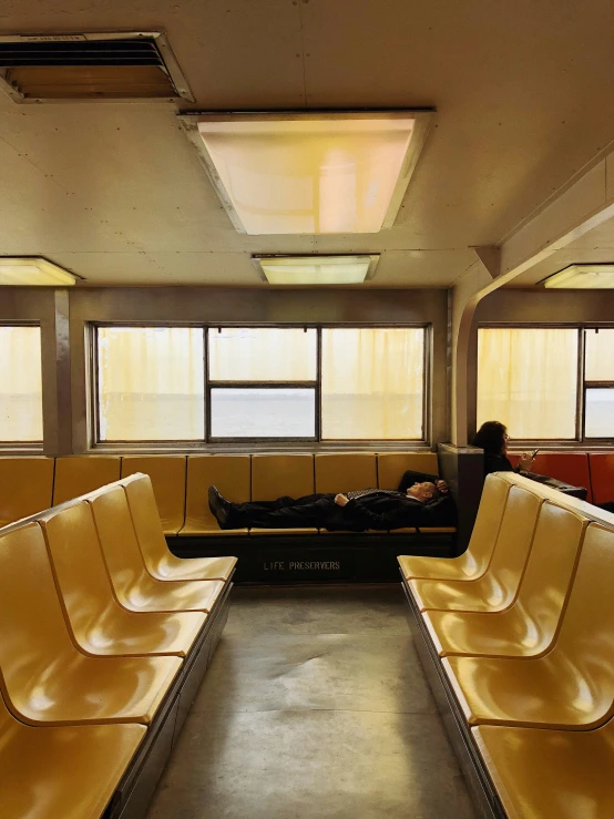 a large room with a person laying down on one of the benches