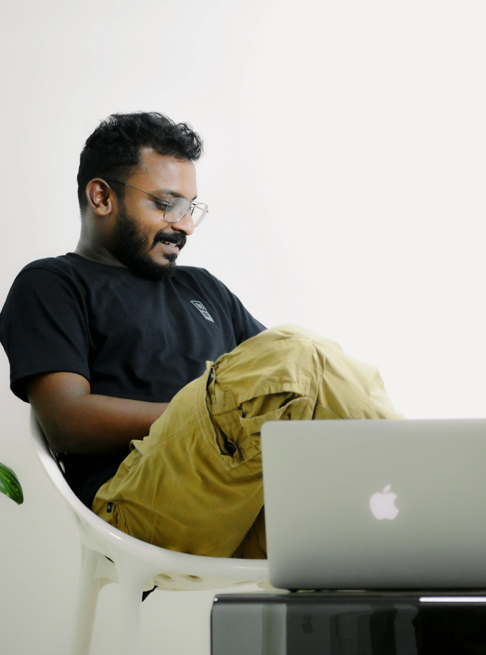 a man sits in a chair using a laptop