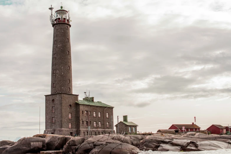 an old, old lighthouse is on the rocky shore
