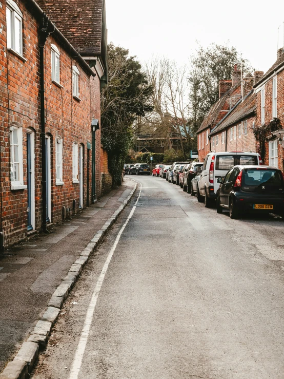 a road is lined with cars and small houses