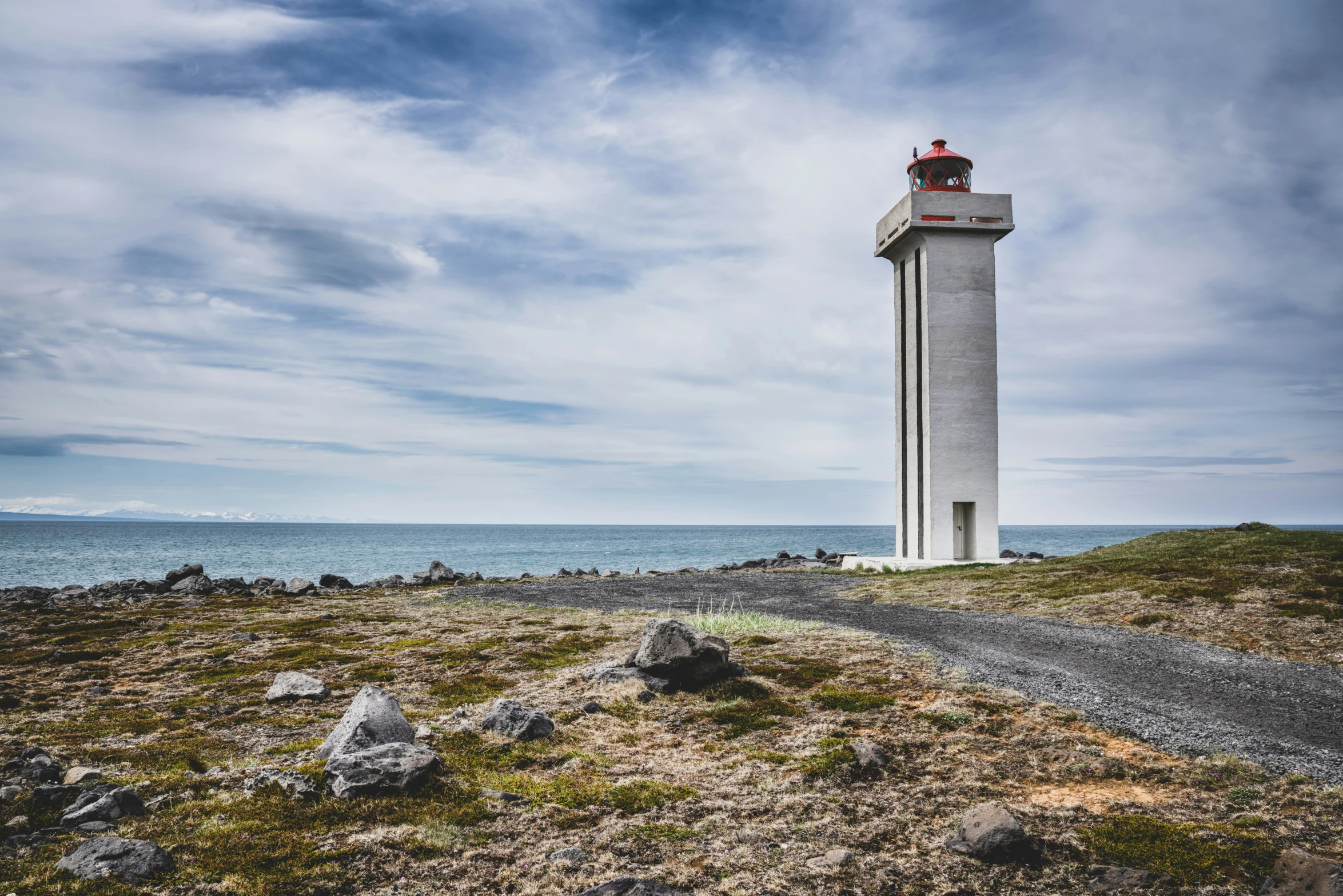 the lighthouse stands on a beach and looks out over the water