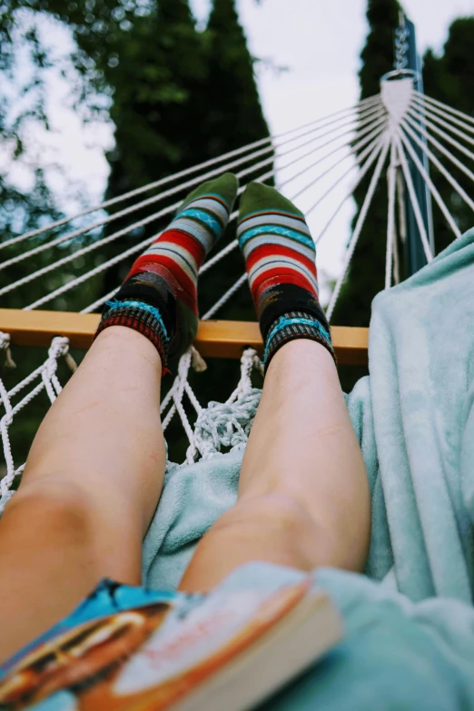 there is a woman in the hammock with her feet in the air