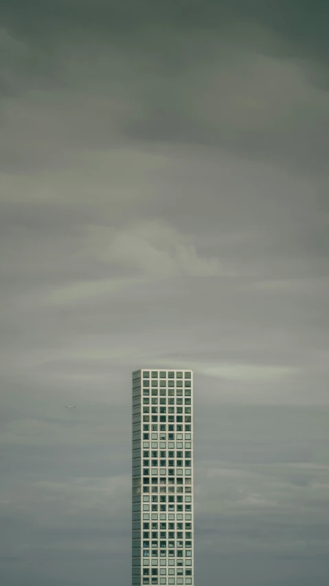 large white skyscr in front of dark, cloudy sky