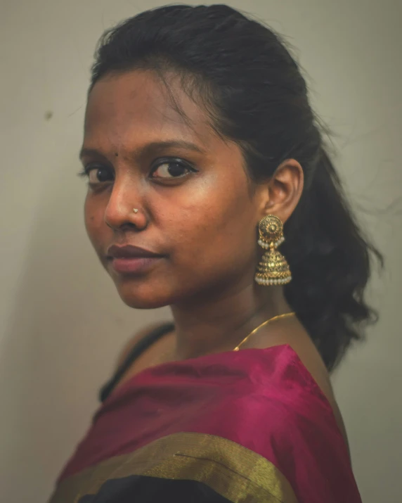 a woman with an earring is staring at the camera