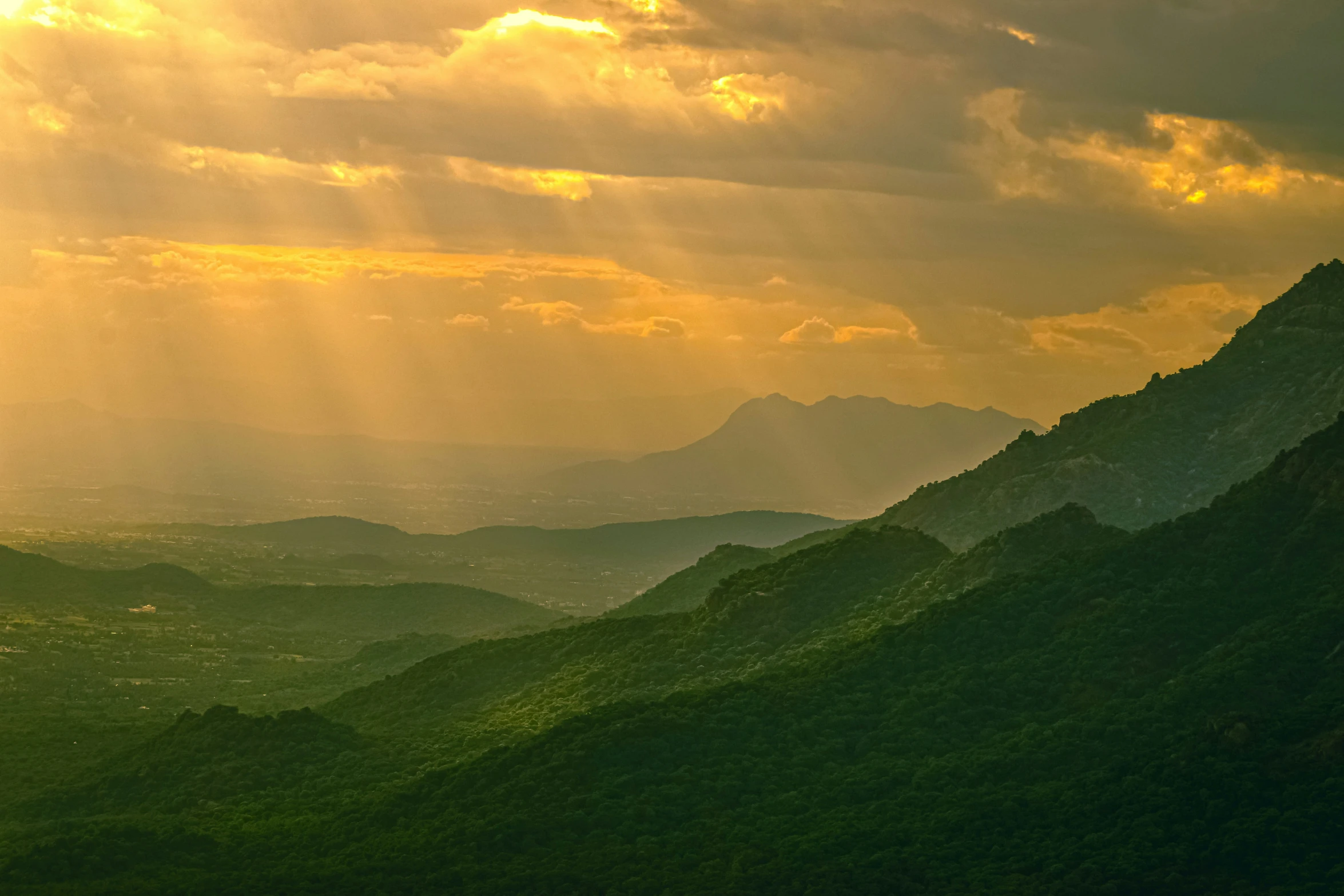 bright sun beams break through the clouds over the mountains