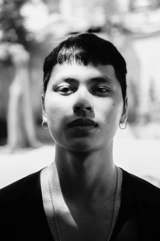 a black and white image of a woman in front of some trees