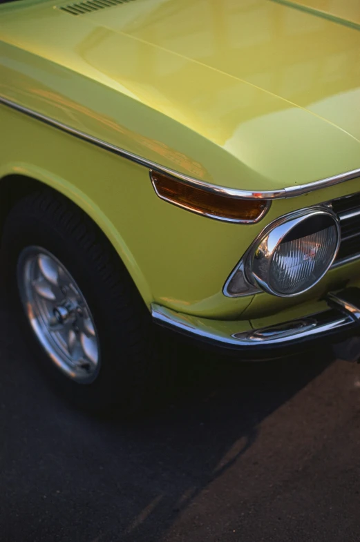 a yellow car that has been parked by the curb