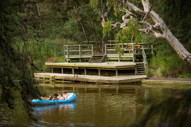 two people on a raft in a lake near a dock