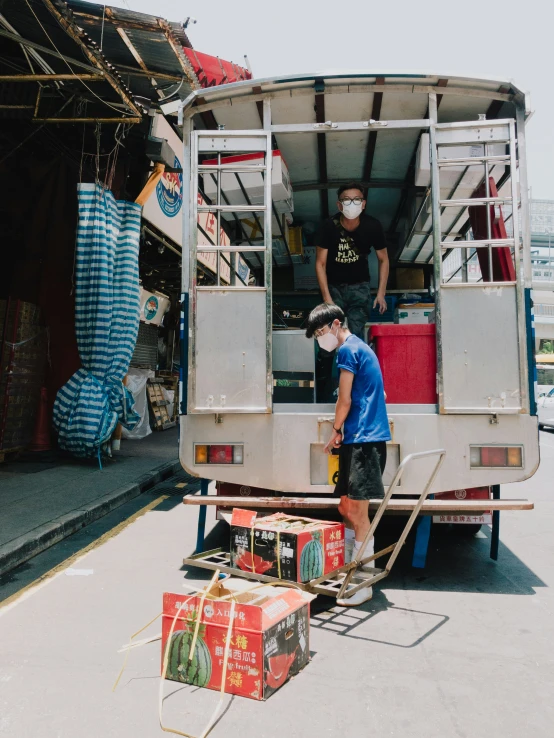 a man unloading items in the back of a vehicle