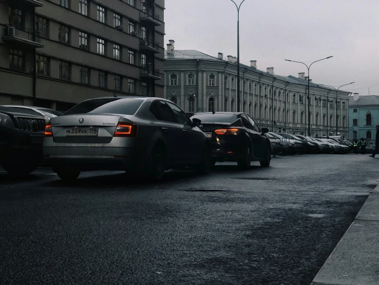 a car waiting at the stop light near a bunch of parked cars