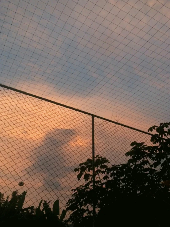 clouds seen through a fenced in area