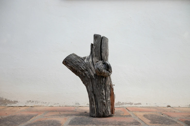 a statue of a tree trunk sits on some bricks