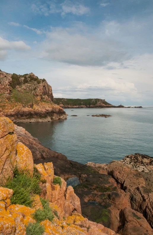 an open area with a body of water near some rocks