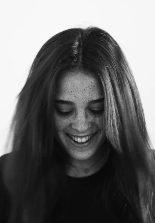 a woman with long hair smiling at the camera