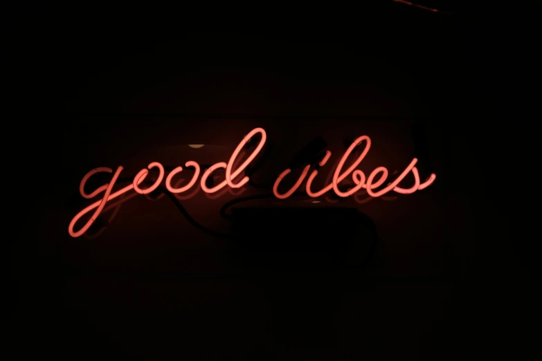 a bright pink neon sign that reads good vibes