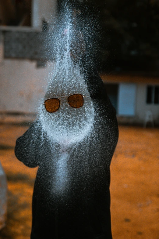 a person wearing sunglasses is covered in snow