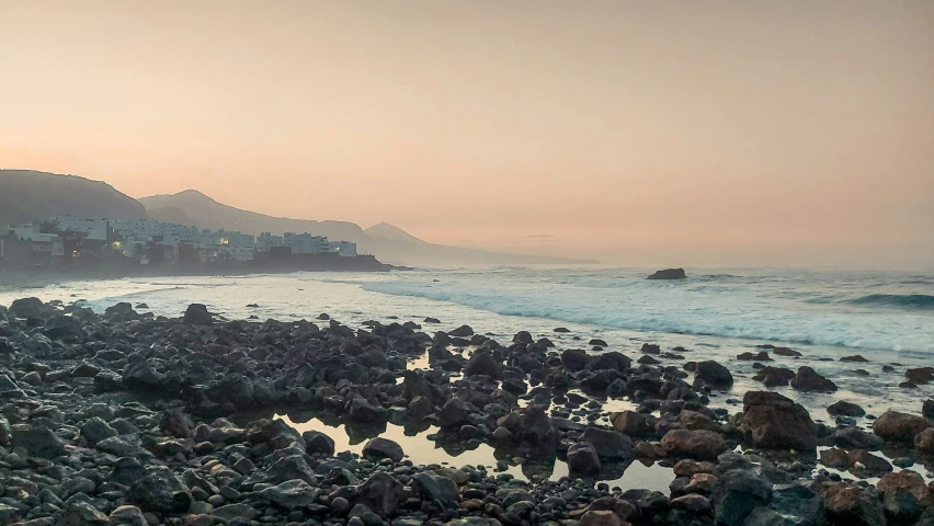 a picture of a sandy beach with rocks