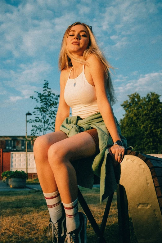 a woman is sitting on a wooden bench in a park