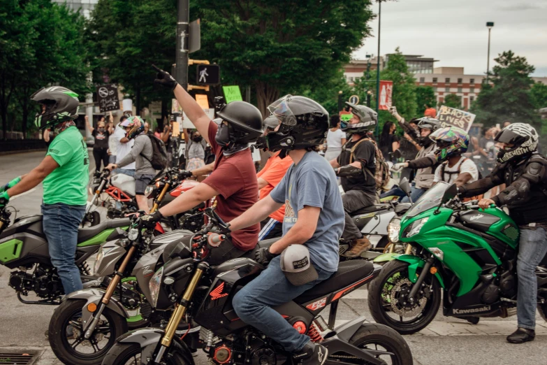 several motorcycle drivers are lined up with helmets