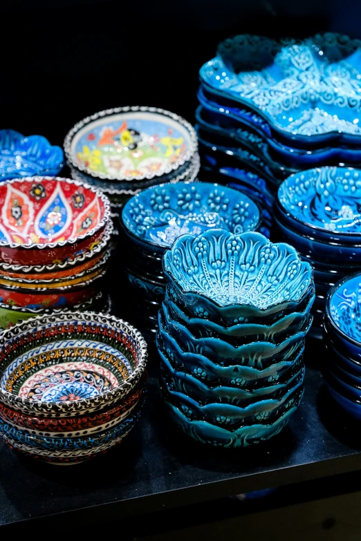 there are many colorful plates on display for sale