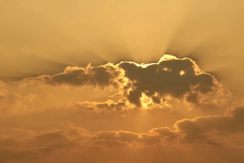 sun setting through some clouds in an overcast sky