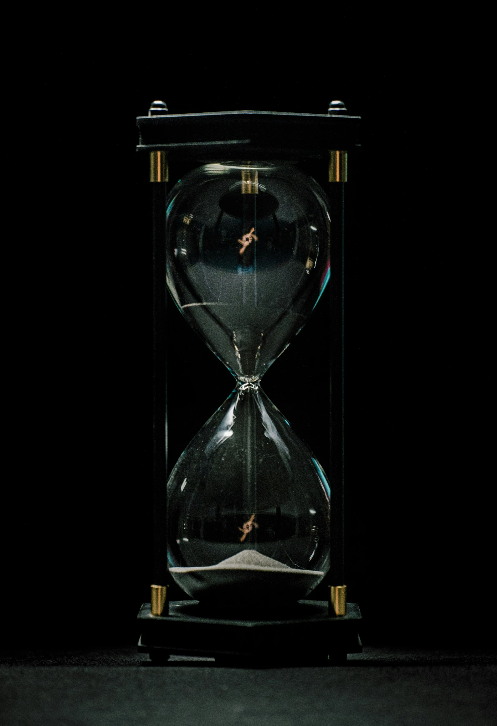 an old time hour glass clock with a black back